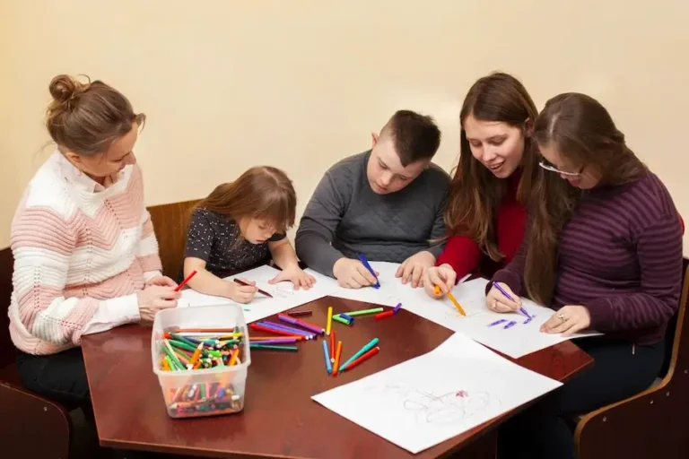 Volunteers coloring with foster children