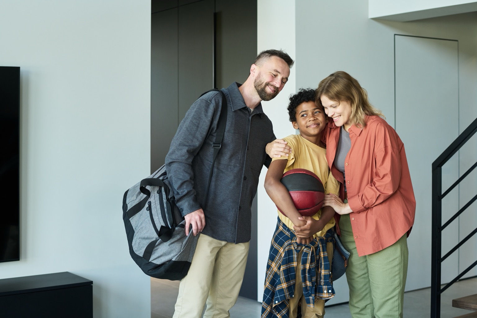 Foster parents welcoming their son home at the front door after practice