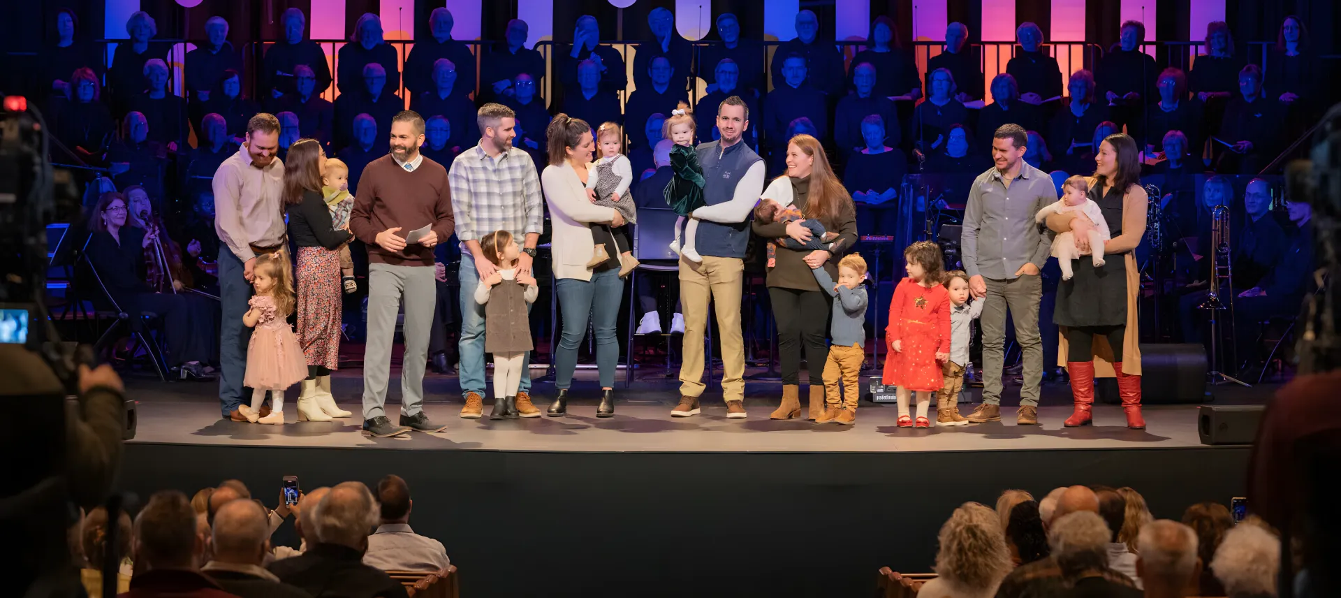 Families with young children on stage during a child dedication service at a partner church