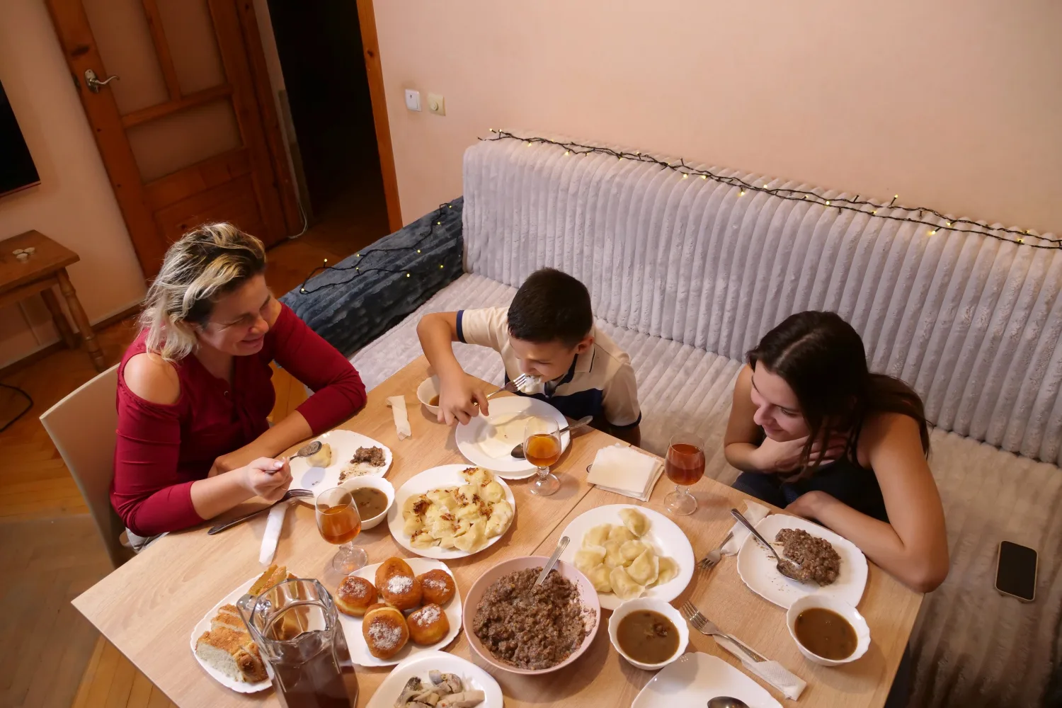 A mother and two children sharing a home-cooked meal together around the dinner table