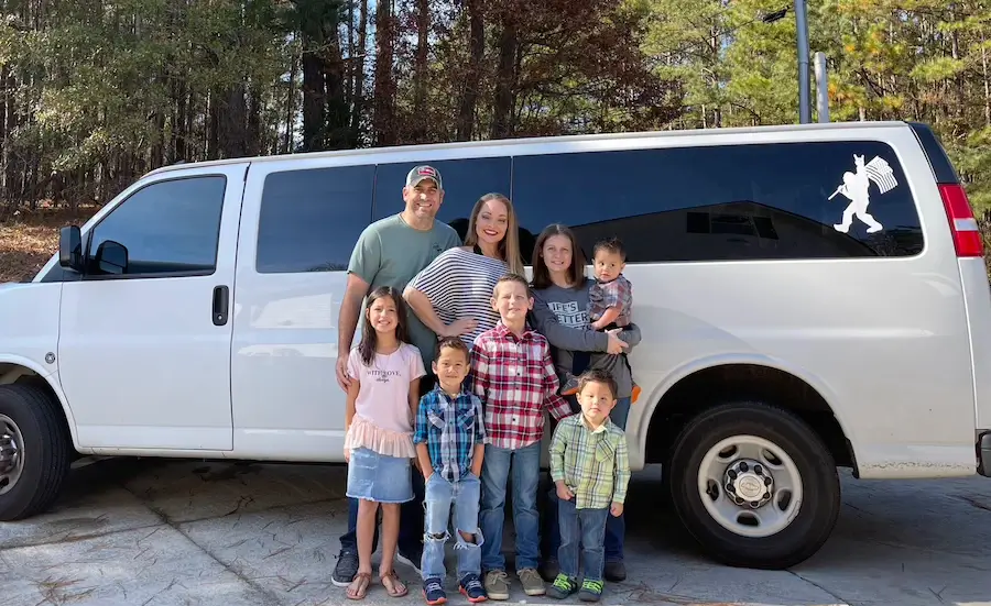 Foster family in front of a white van